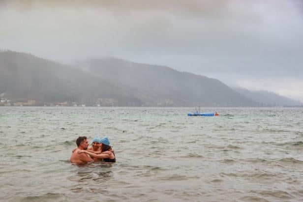 Drei Menschen im Kreis bei Nebel im Attersee, halten sich an den Schultern