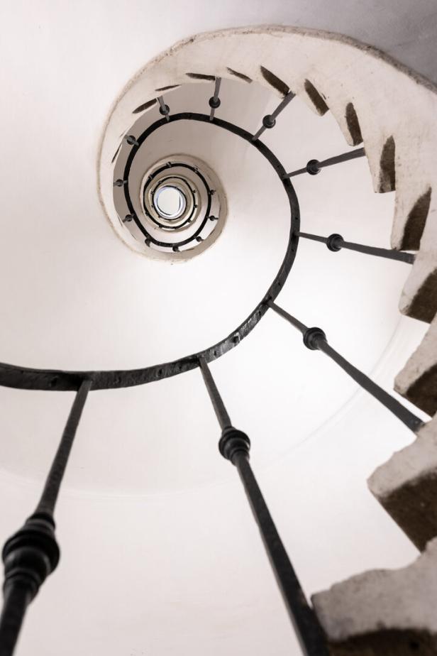Eine enge Wendeltreppe schlengelt sich steil nach oben.