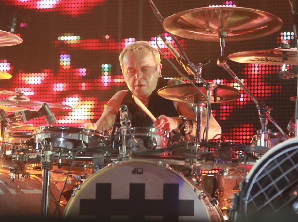 Drummer mit blonden Haaren beim Schlagzeug vor einer LED-Wand.