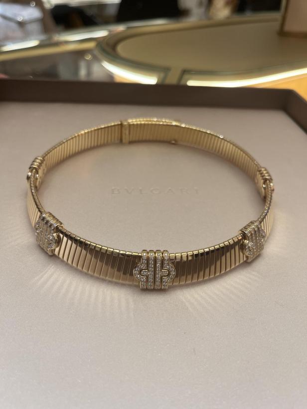 Ein goldenes Bulgari Halsband mit Diamanten liegt in einer Schachtel.