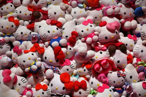 Eine große Sammlung von Hello Kitty Stofftieren mit verschiedenen Schleifen und Kostümen.