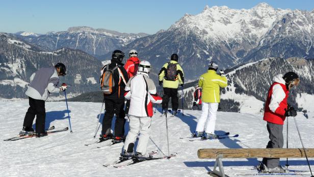 Eine Gruppe von Skifahrern genießt die Aussicht auf die schneebedeckten Berge.