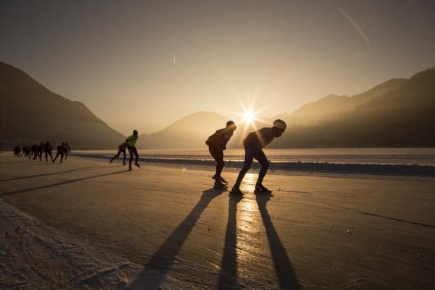 Eisschnellläufer am Weissensee bei Sonnenuntergang