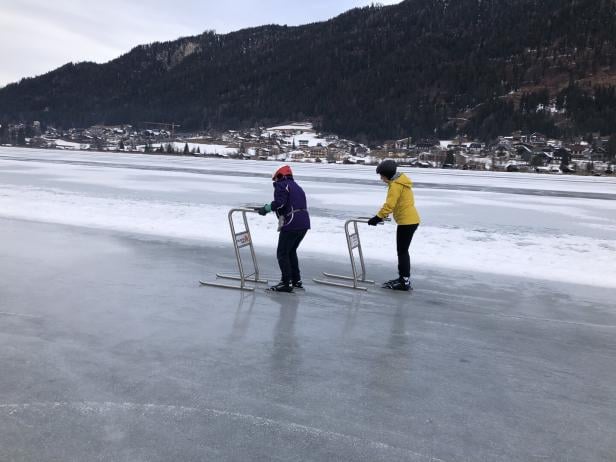 Zwei Anfänger beim Eisschnelllauf am Weissensee mit Eislaufhilfen