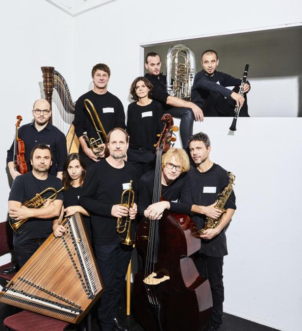 Eine Gruppe von Musikern posiert mit ihren Musikinstrumenten für ein Foto.