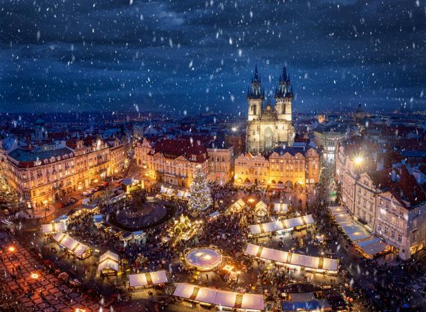 Ein Weihnachtsmarkt auf dem Altstädter Ring in Prag im Schneefall.