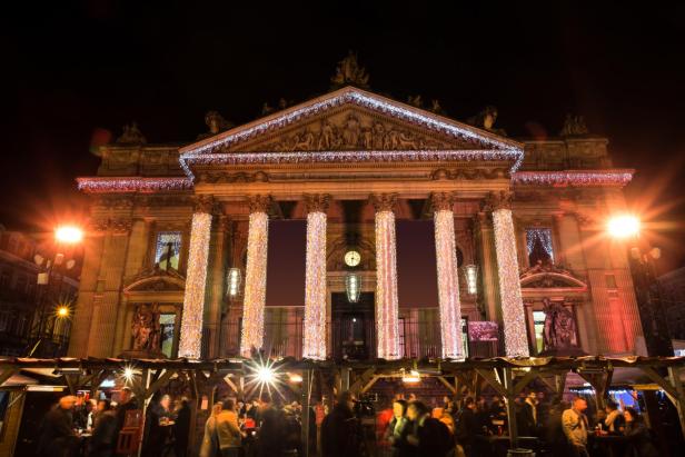 Der Christkindlmarkt Winterpret vor dem beleuchteten Börsengebäude in Brüssel.