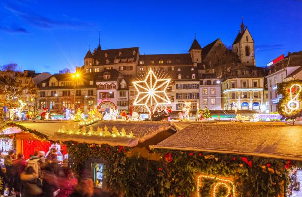 Christkindlmarkt oder Weihnachtsmarkt in Basel bei Nacht.