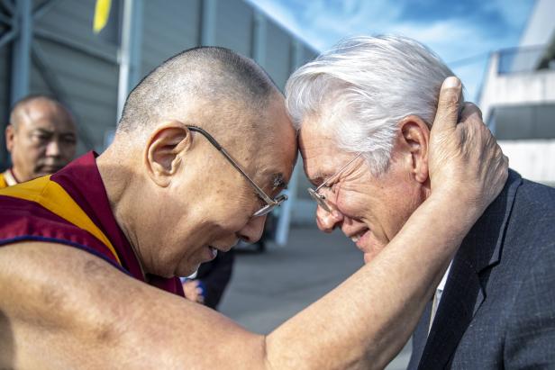 Der Dalai Lama berührt mit seiner Stirn die Stirn einer anderen Person.