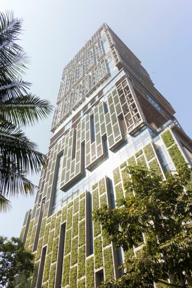 Ein Hochhaus mit vertikalen Gärten und Palmen im Vordergrund.