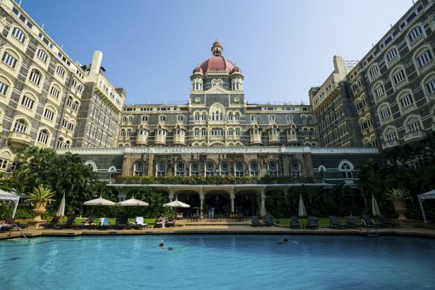 Das Taj Mahal Palace Hotel in Mumbai mit einem Schwimmbad im Vordergrund.
