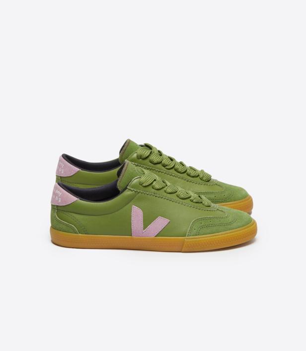Ein Paar grüne Veja-Sneakers mit rosa Details stehen auf einem weißen Hintergrund.