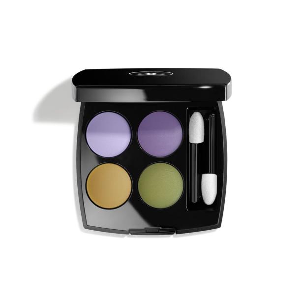 Eine Palette mit vier Lidschatten in Lila-, Gold- und Grüntönen.