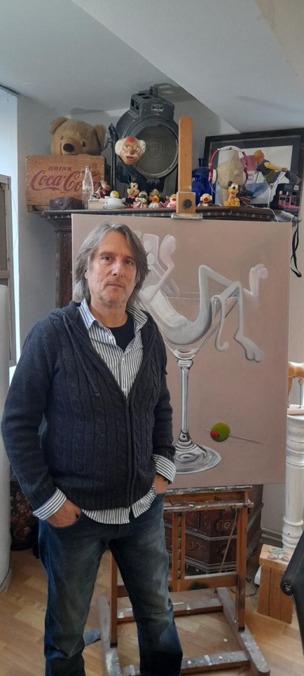 Der Künstler steht vor einer Staffelei, auf der ein noch unfertiges Pink-Panther-Bild hängt.