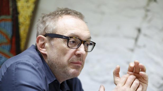 Ein Mann mit Brille gestikuliert während eines Gesprächs.