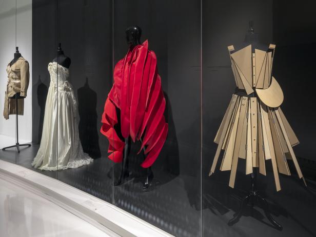 In einer Vitrine sind vier verschiedene Kleider auf Schaufensterpuppen ausgestellt.