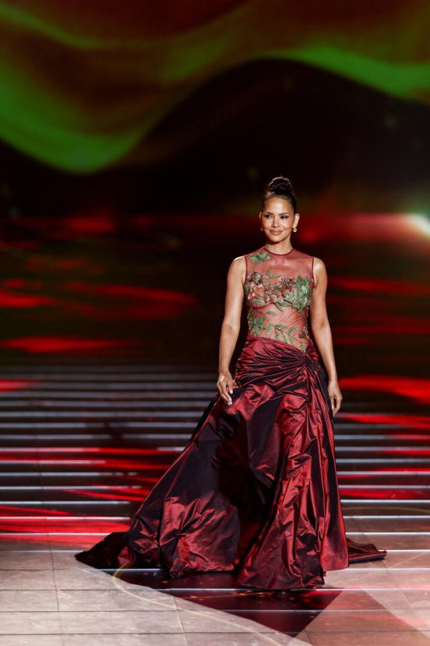 Halle Berry in einem roten Kleid mit Blumenmuster auf einer Bühne.