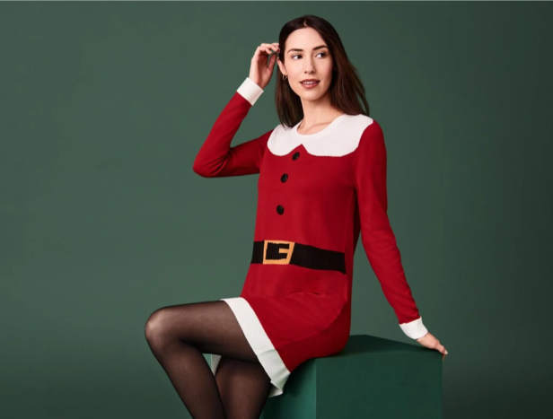 Eine Frau in einem roten Weihnachtskleid von Lidl sitzt auf einem grünen Hocker.
