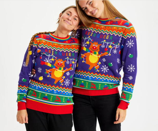 Zwei Frauen tragen „ReinQueer“-Weihnachtspullover von Christmas Sweats.