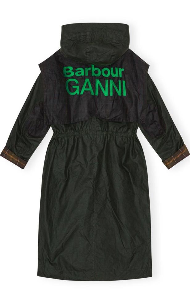 Eine lange, dunkle Regenjacke mit Kapuze und dem grünen Schriftzug „Barbour Ganni“ auf dem Rücken.