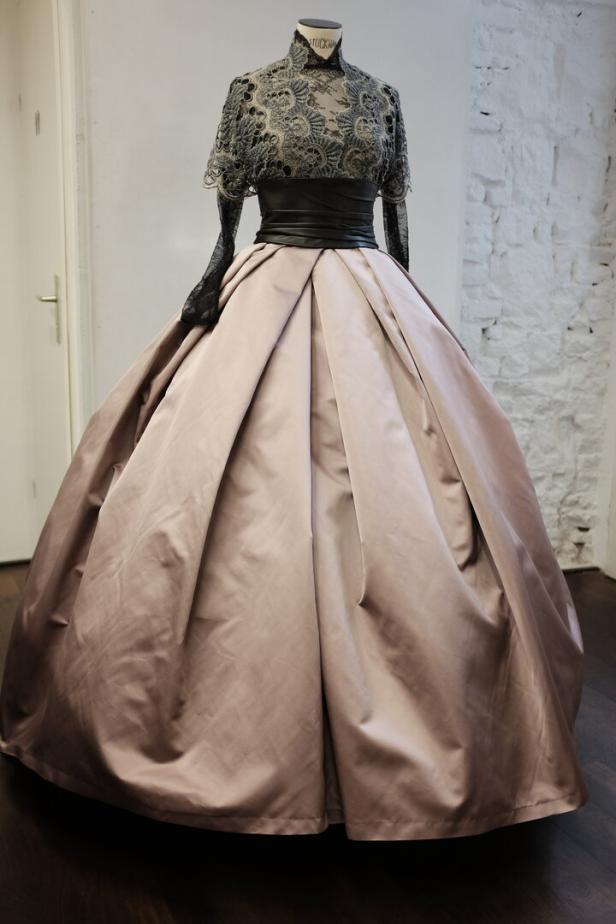 Ein elegantes, bodenlanges Ballkleid mit Spitze und einem weiten, beigefarbenen Rock.