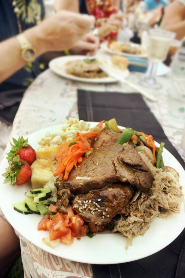 Ein Teller mit Fleisch, Gemüse und Beilagen wird bei einem Essen serviert.