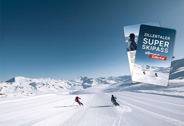 Zwei Personen fahren Ski auf einer verschneiten Piste, im Hintergrund ist der Schriftzug "Zillertaler Super Skipass" lesbar.