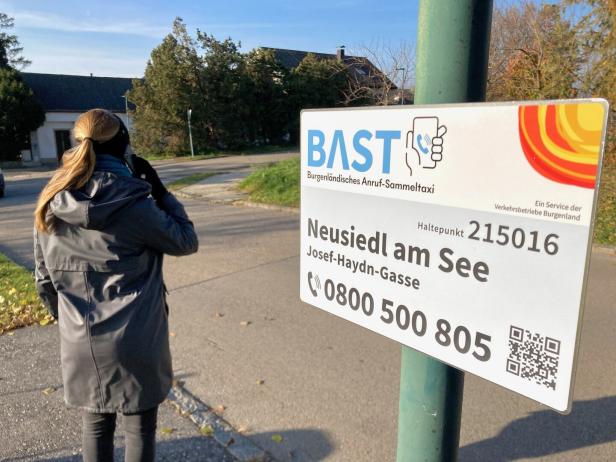 Eine Frau telefoniert an der BAST-Haltestelle Neusiedl am See, Josef-Haydn-Gasse.