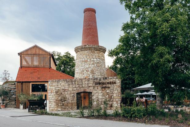 Das Ziegelwerk Gasthaus mit einem markanten Schornstein und einem modernen Anbau.