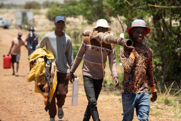 Volunteers in a rescue operation to bring miners to the surface in a standoff between the police and illegal gold miners return from a mineshaft in Stilfontein