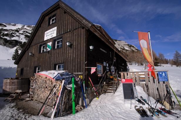 Grazer Hütte im Winter, davor stehen Ski