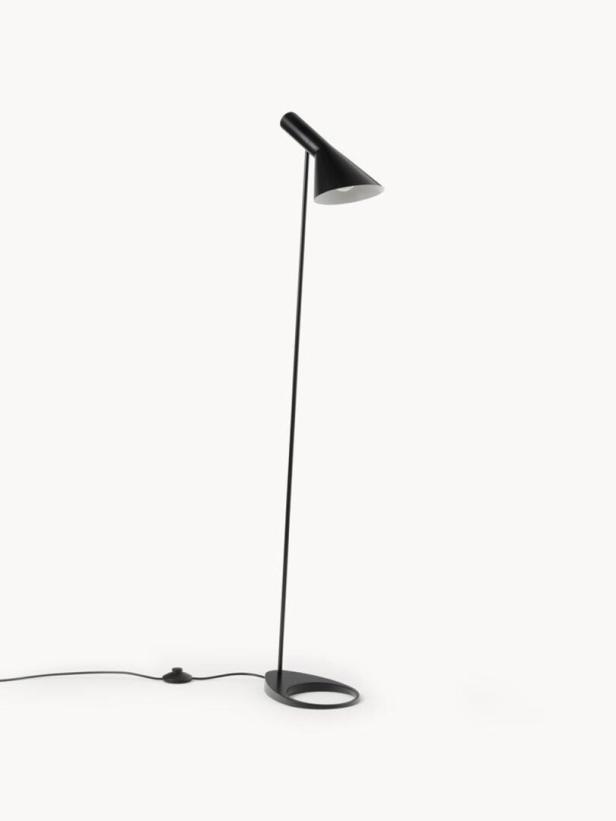 Eine schwarze Stehlampe mit einem konischen Lampenschirm steht auf einem weißen Hintergrund.