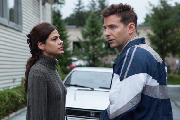 Bradley Cooper und Eva Mendes stehen vor einem Haus und unterhalten sich.
