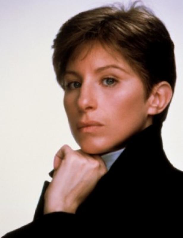 Ein Porträt von Barbra Streisand mit kurzem, braunem Haar und dunklem Blazer.