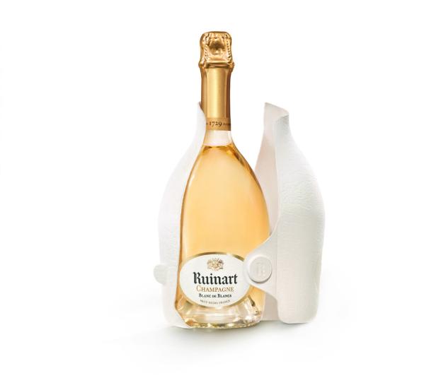 Eine Flasche Ruinart Champagner Blanc de Blancs in einer weißen Schutzverpackung.