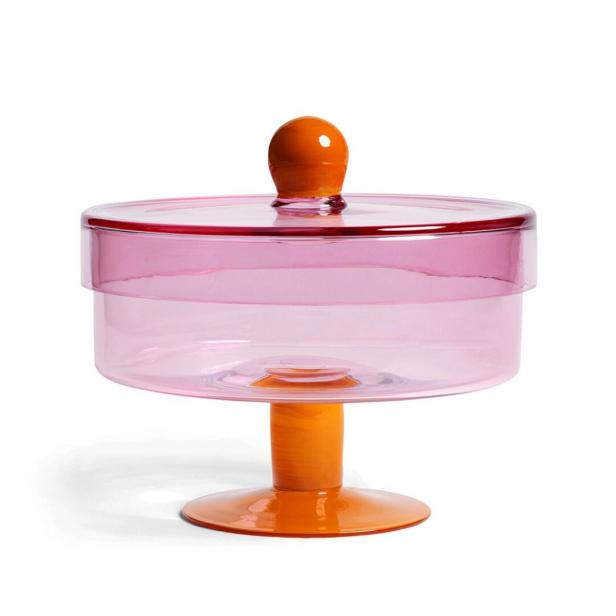 Eine Bonboniere aus rosa Glas mit orangefarbenem Deckel und Fuß.