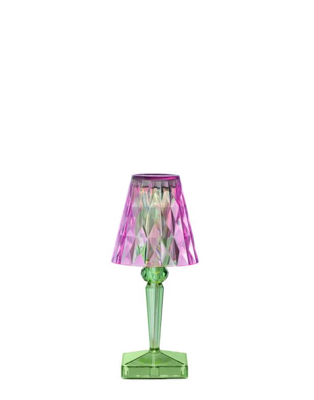 Eine kleine Tischleuchte mit einem rosa Lampenschirm und einem grünen Sockel.