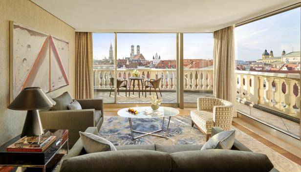 Ein Wohnzimmer im Mandarin Oriental, München, mit Blick auf die Stadt.