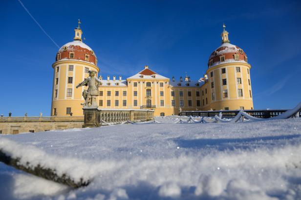 Schloss Moritzburg im Winter mit Schnee und blauem Himmel.