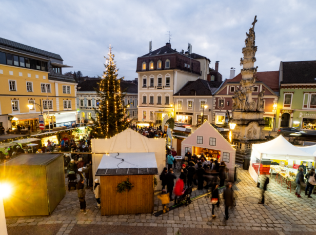 Ein Marktplatz voller Weihnachtsbeleuchtung und einem Weihnachtsmarkt.