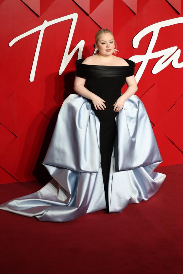 Nicola Coughlan in einem schwarzen Kleid mit hellblauer Schleppe auf dem roten Teppich.