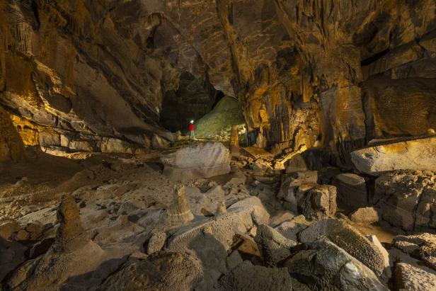 Eine klein wirkende Person inmitten einer riesigen Höhle.