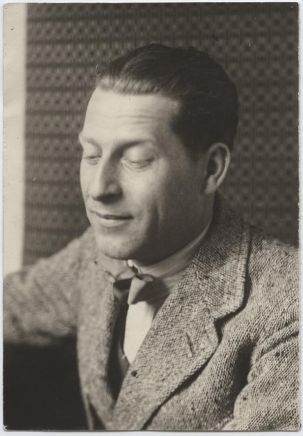 Ein Mann mit geschlossenen Augen trägt einen Tweed-Anzug mit Fliege.