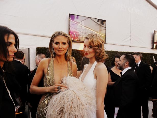 Heidi Klum und eine weitere Frau posieren auf dem roten Teppich.
