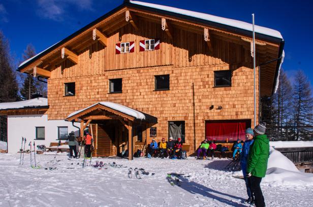 Kleinarler Hütte im Winter, Skifahrer und Skitourengeher stehen davor