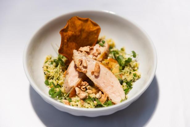Gambische Maafe mit Hähnchen, Couscous und einem Süßkartoffel-Chip.