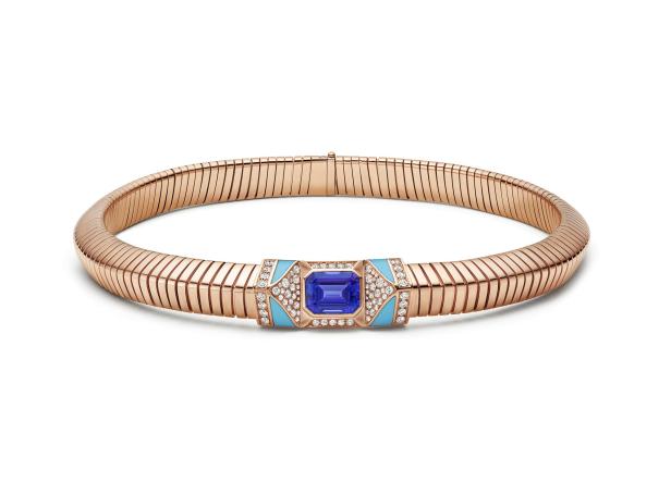 Ein goldenes Armband mit einem blauen Edelstein und türkisfarbenen Akzenten.
