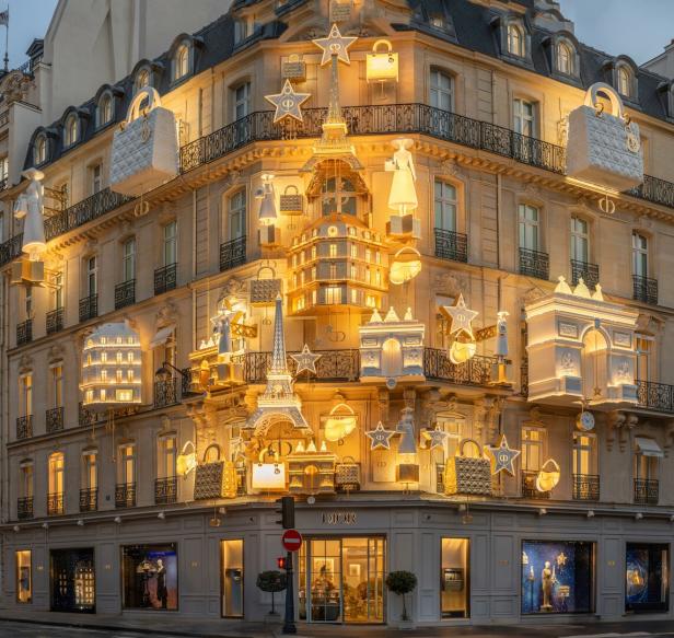 Auf der Hausfassade von Dior in Paris hängen neben Sternen der Eiffelturm oder der Triumphbogen wie ein großer Weihnachtsschmuck.