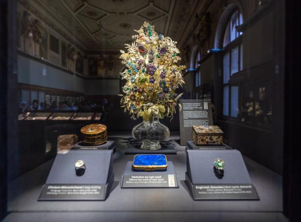 Schmuckstücke in einer Vitrine der Edelsteinsammlung. Unter anderem ein prunkvoller, glitzernder Strauß voll von Edelsteinen und Edelmetall.