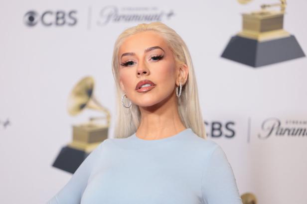 Christina Aguilera posiert vor einem Hintergrund mit CBS- und Paramount+-Logos.